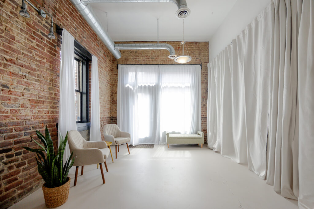 beautiful natural light studio with exposed brick and white walls